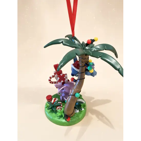 Disney Christmas Stitch and Angel figurine under a palm tree