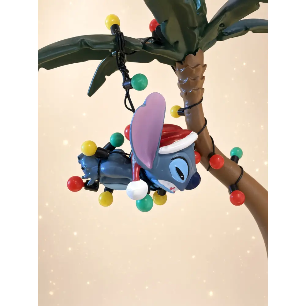Disney Christmas Stitch and Angel figurine under a palm tree